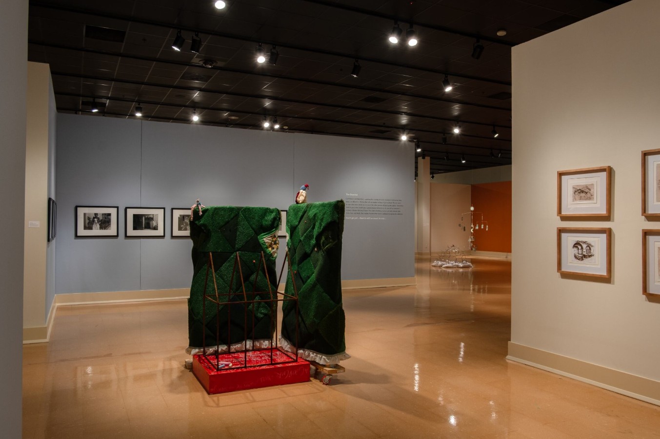 Rylee Brabham (born 2001), Hedge of Protection, 2025; Installation view; Steel, plywood, two-by-fours, AstroTurf, the artist’s great-great grandmother’s quilt blocks, batting, thread, lace, red paint, bronze cast of Mr. Baby